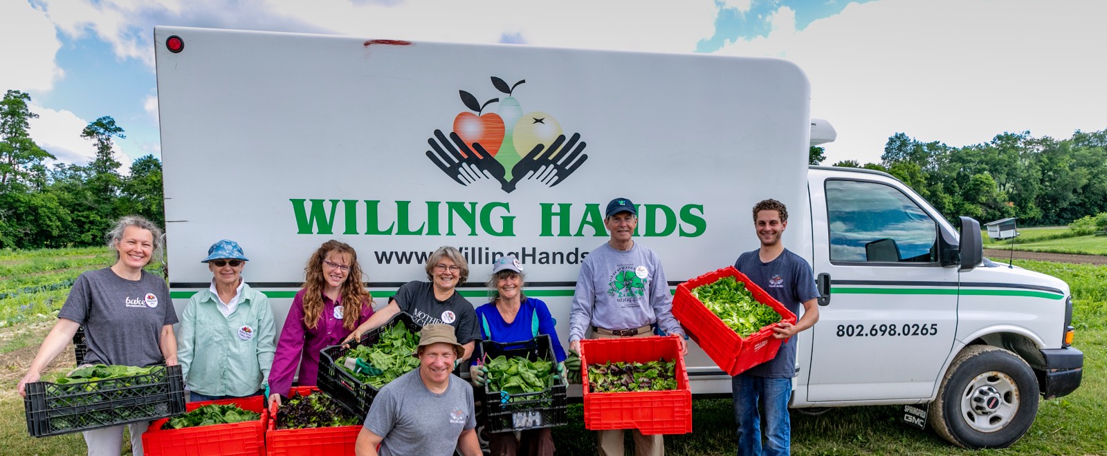 Volunteers with bins of gleaned vegetables in front of the Willing Hands truck